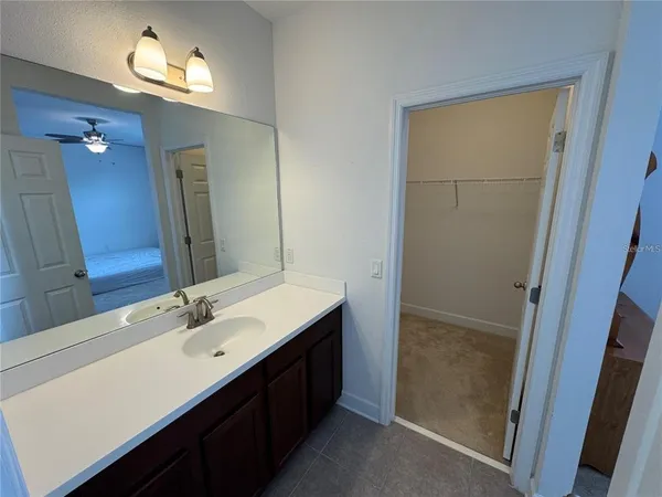 a bedroom with a bed and a ceiling fan