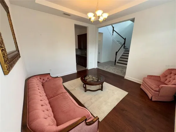 a living room with furniture and a chandelier