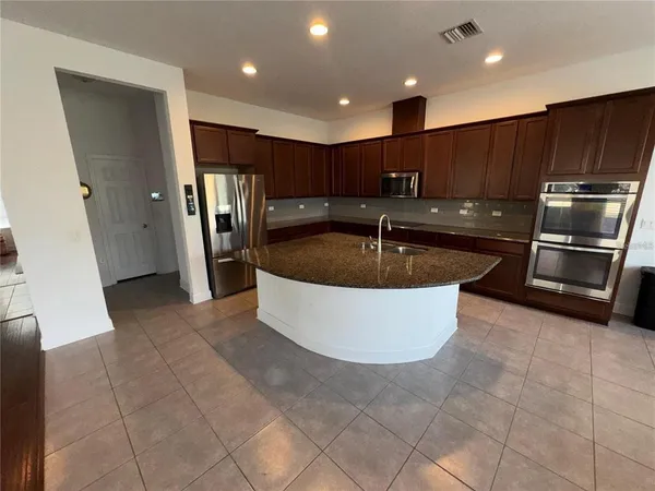 a view of kitchen with stainless steel appliances granite countertop sink and stove