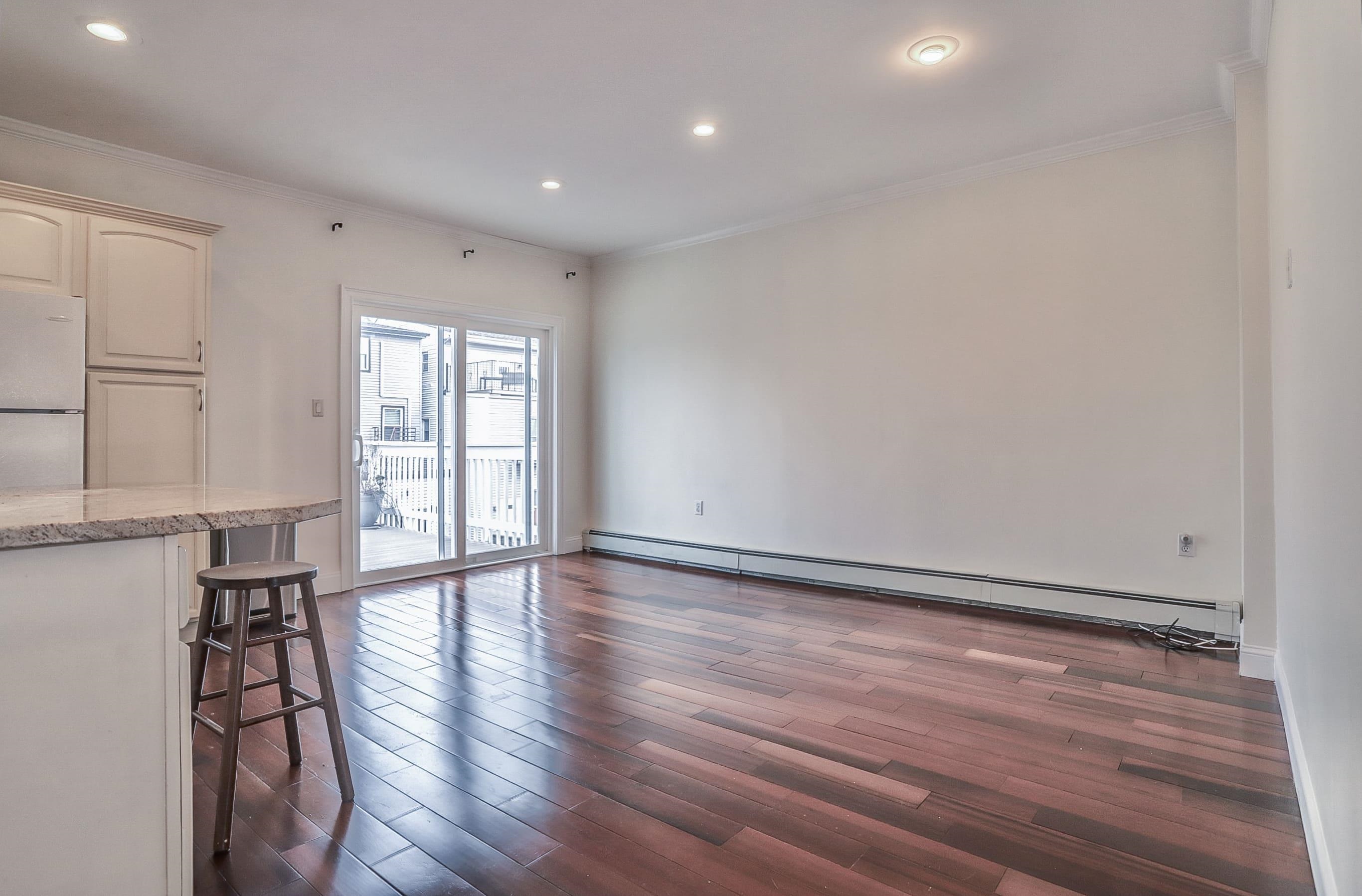 206 Dodd Street, Unit 2 Weehawken, NJ 07086 - Photo 6 of 20 a view of an empty room with wooden floor and a window