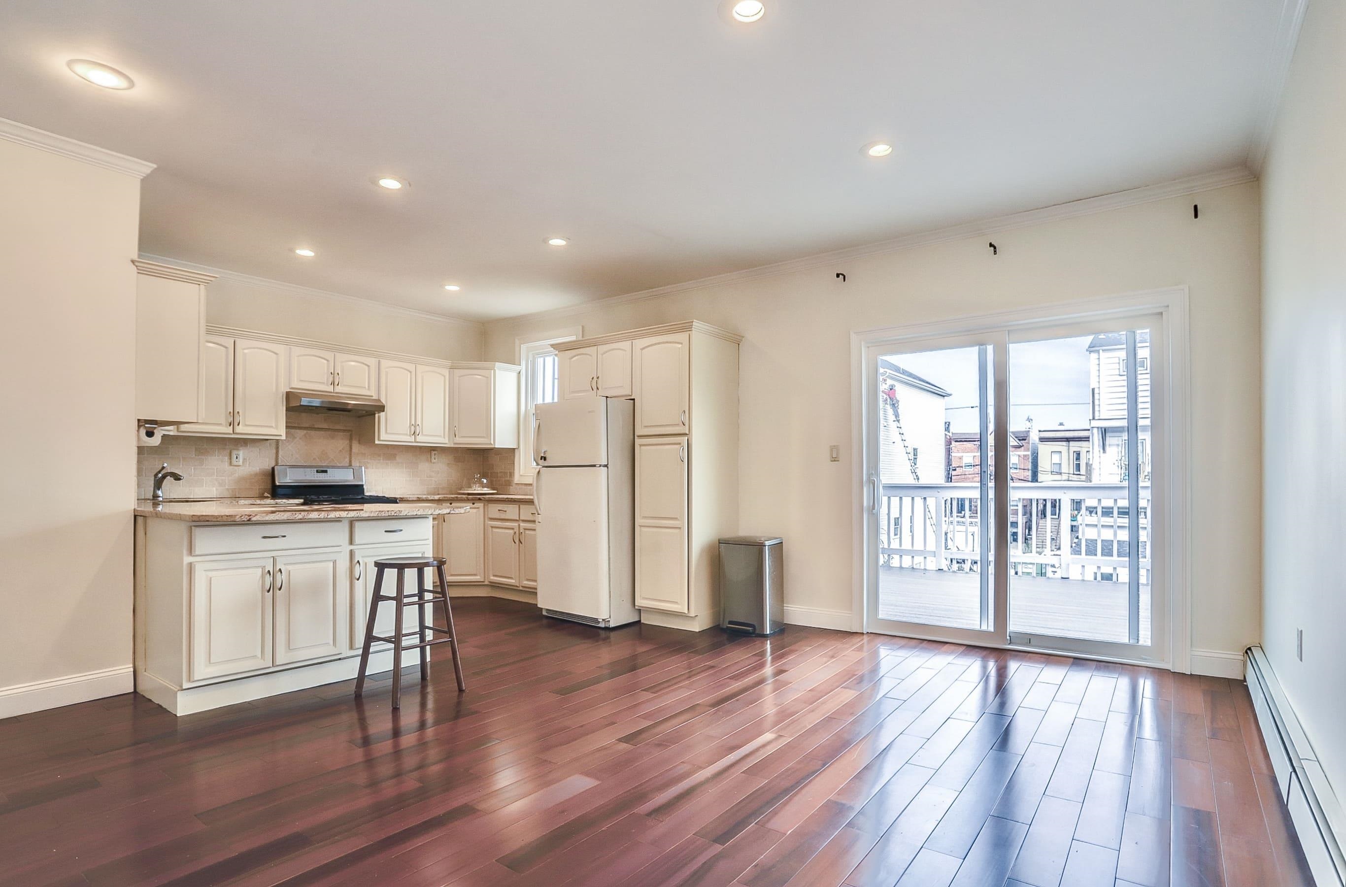 206 Dodd Street, Unit 2 Weehawken, NJ 07086 - Photo 7 of 20 a kitchen with stainless steel appliances wooden floors and white cabinets