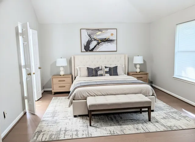 a bedroom with a bed lamp and a window