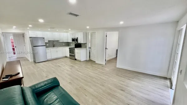 a living room with furniture and kitchen view