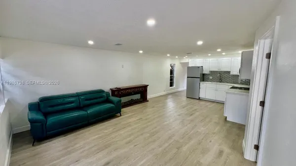 a view of kitchen with stainless steel appliances kitchen island hardwood floor and a sink