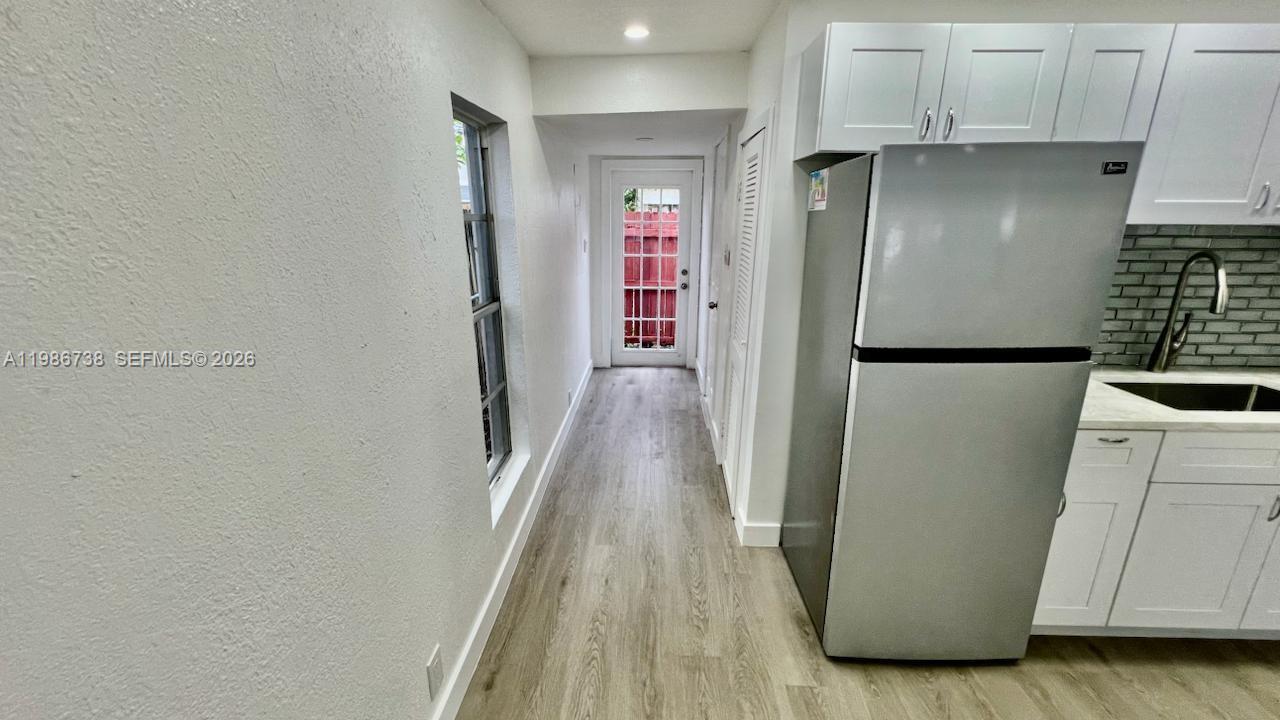 48 Southwest 14th Street Dania Beach, FL 33004 - Photo 9 of 13 a view of a kitchen with refrigerator and wooden floor