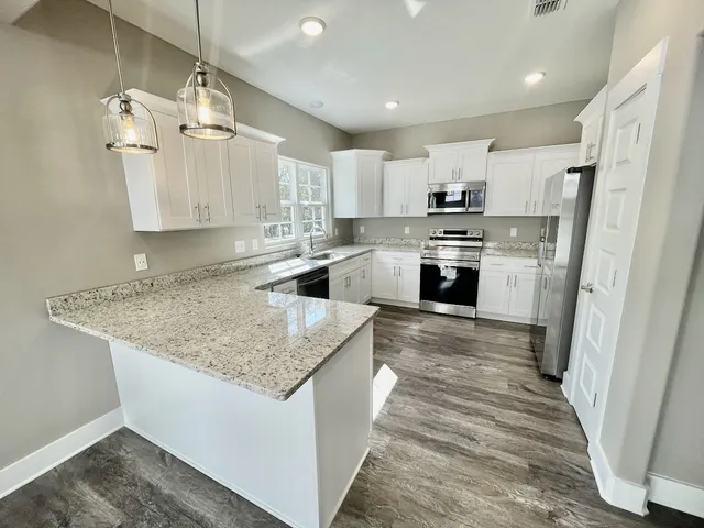 a kitchen with stainless steel appliances granite countertop a sink stove and refrigerator