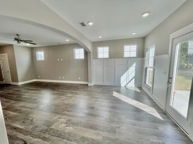 an empty room with wooden floor and a large window