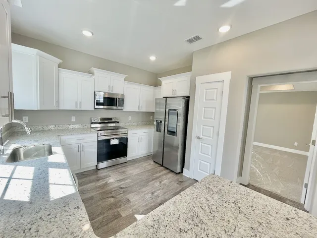 a kitchen with granite countertop a refrigerator and a sink