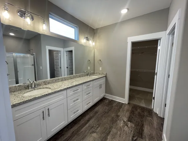 a spacious bathroom with a granite countertop sink and a mirror
