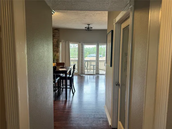 a view of a hallway with wooden floor windows and chairs