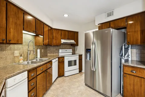 a kitchen with stainless steel appliances granite countertop a refrigerator and a sink