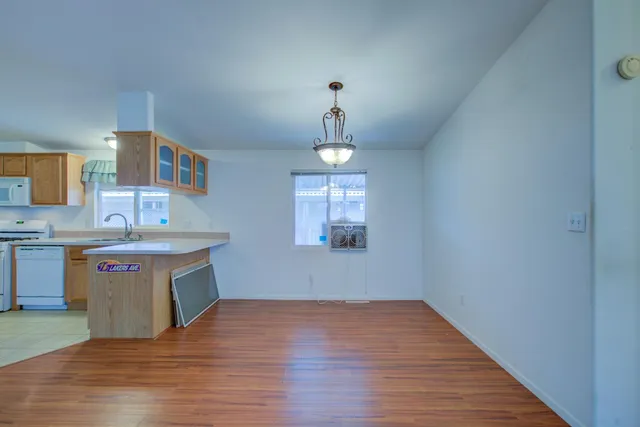 a kitchen with stainless steel appliances granite countertop a sink cabinets and wooden floor