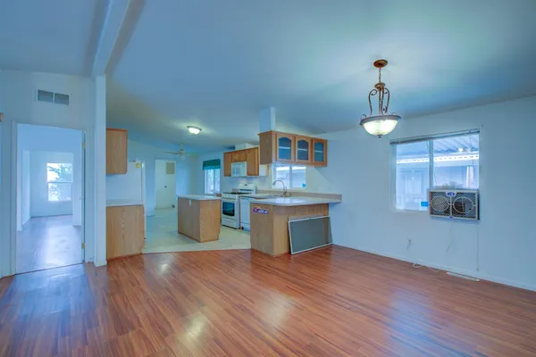 a kitchen with kitchen island stainless steel appliances sink and wooden floor