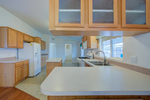 a living room with furniture a flat screen tv and kitchen view
