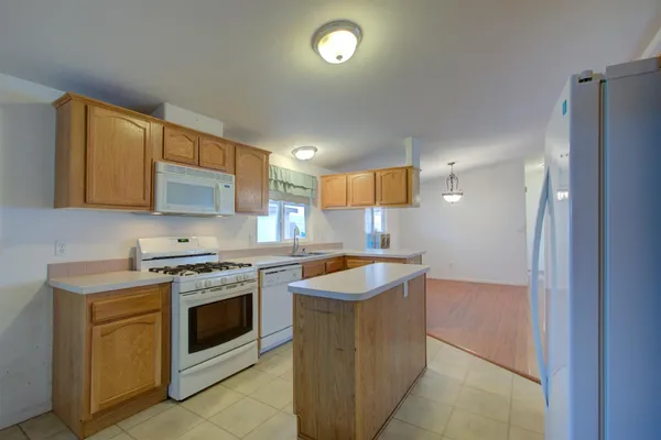 a kitchen with stainless steel appliances granite countertop a stove a sink and a refrigerator