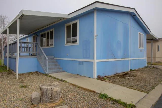 a backyard of a house with table and chairs