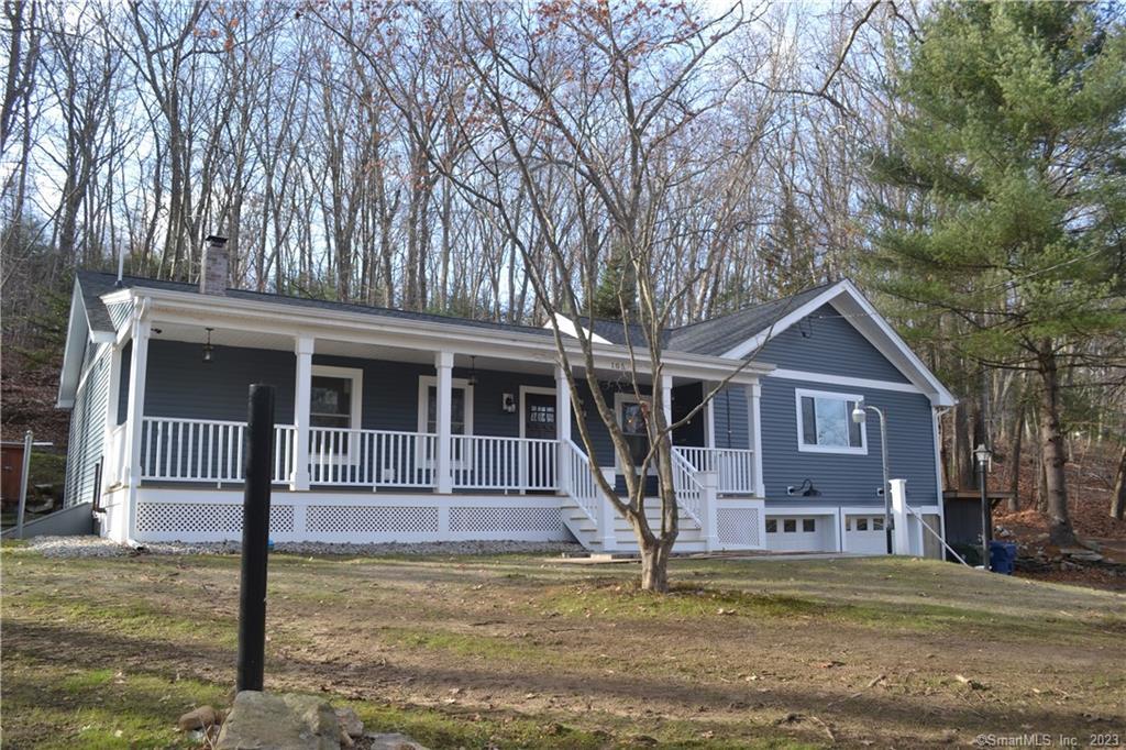 a front view of a house with a yard garage and trees