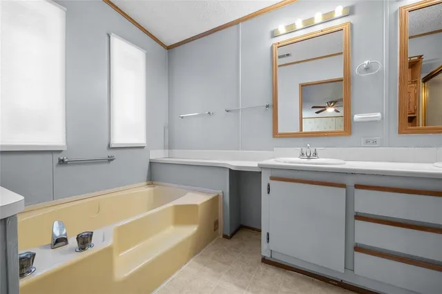a bathroom with a tub sink and mirror