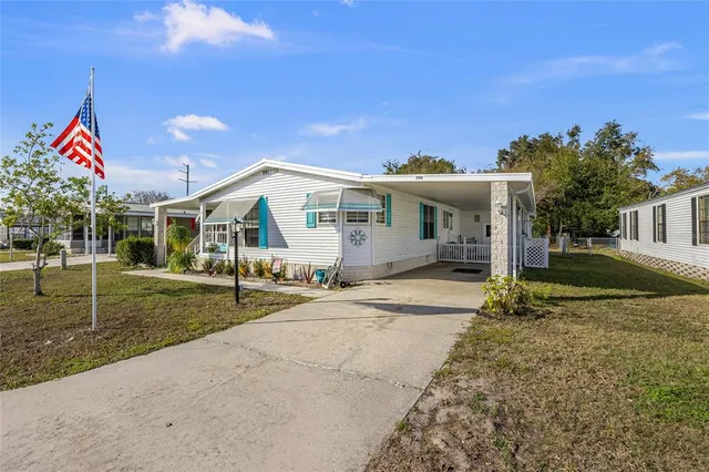 a view of a house with backyard and a tree
