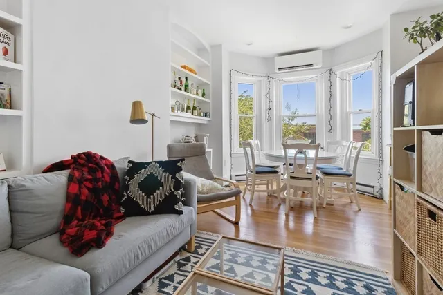 a living room with furniture and a painting on the wall