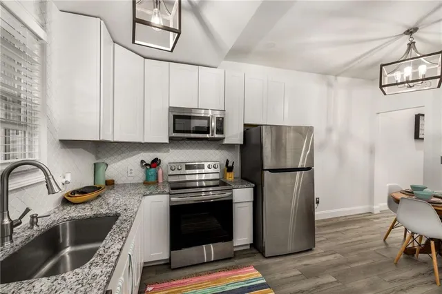 a view of a dining room with furniture a chandelier and wooden floor