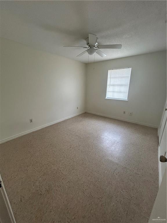 512 Gastel Circle, Unit 5 Edinburg, TX 78539 - Photo 9 of 10 an empty room with a chandelier fan and windows