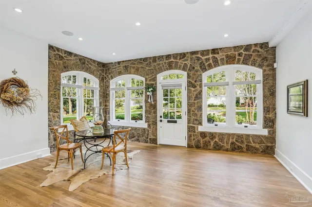 a dining room with wooden floor a chandelier a wooden table and chairs