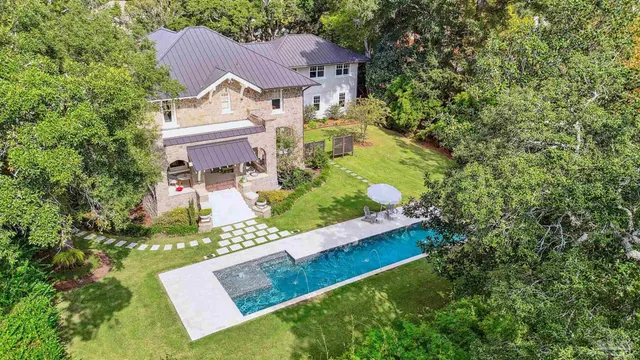 a kitchen with stainless steel appliances kitchen island granite countertop a stove a sink a refrigerator and white cabinets with wooden floor