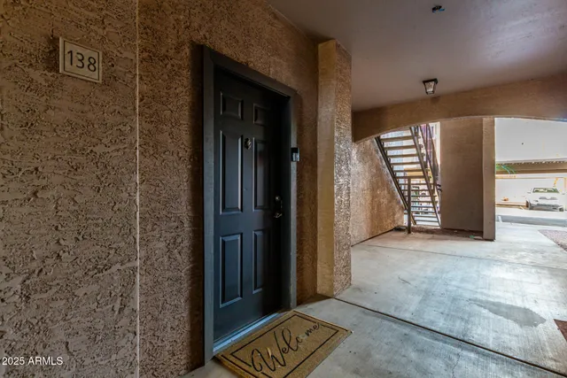 a view of a hallway with wooden floor and a bathroom