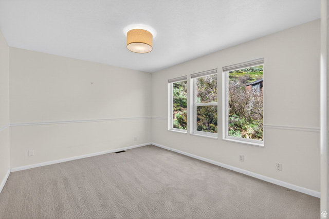 380 Luzern Road Midway, UT 84049 - Photo 30 of 74 Neutral-toned carpeting enhances this bright room featuring multiple windows, a ceiling-mounted light fixture, and crown molding details