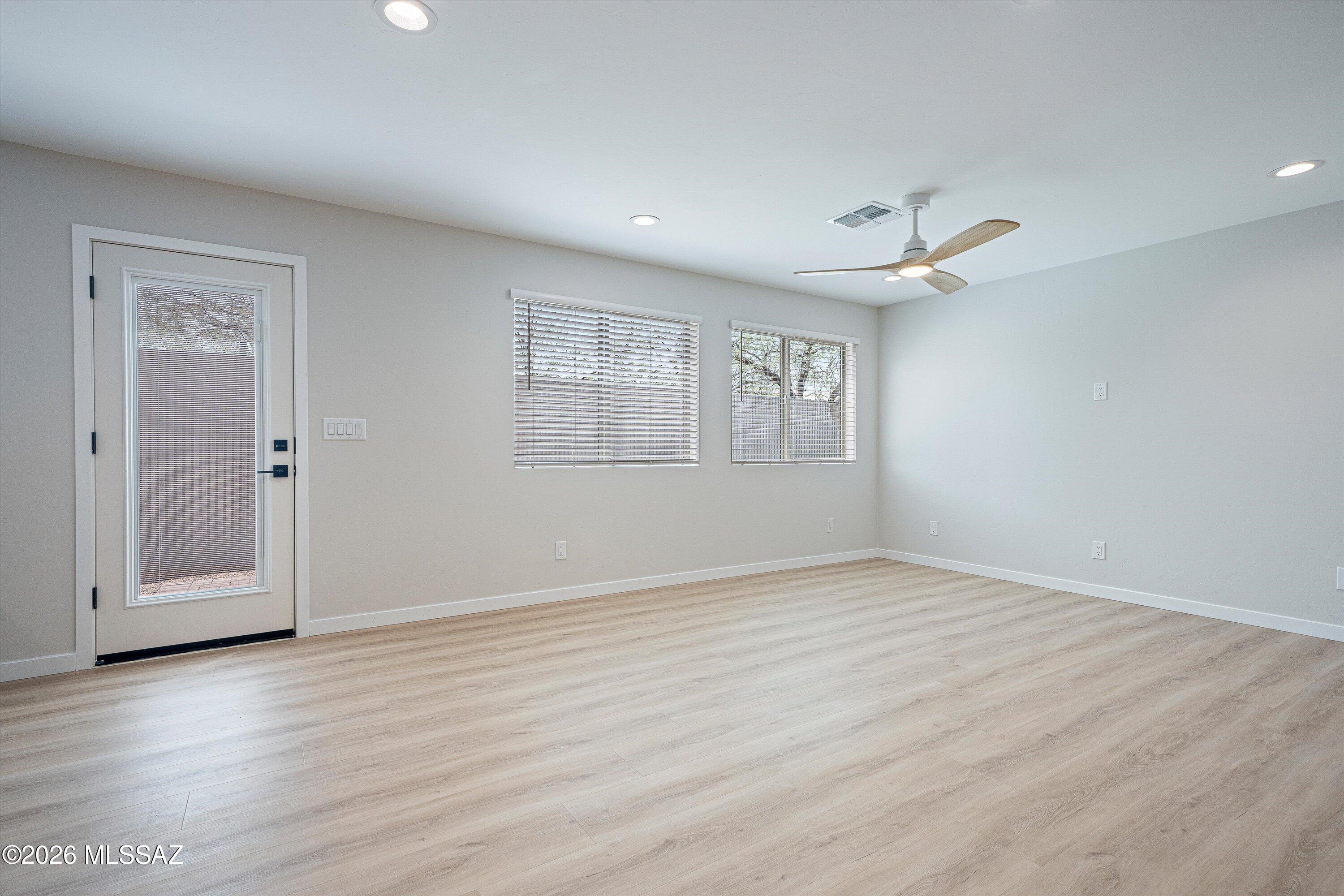 739 North Queen Avenue, Unit 2 Tucson, AZ 85705 - Photo 4 of 28 an empty room with wooden floor cabinet and windows