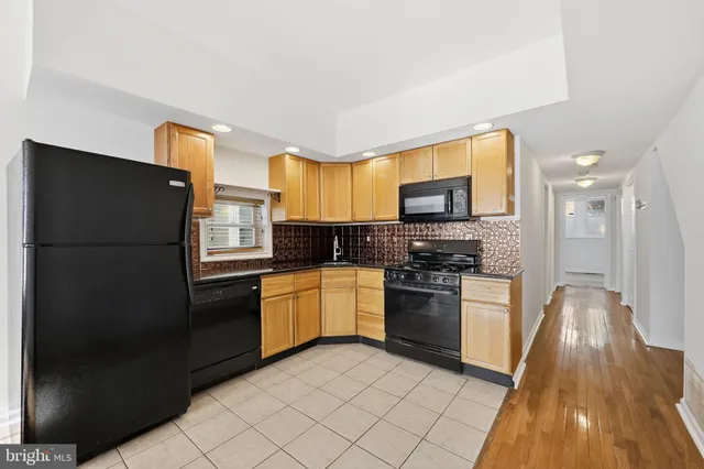 a kitchen with a refrigerator and a stove top oven