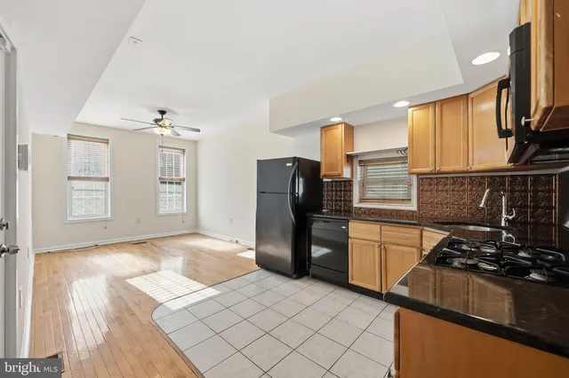 a kitchen with a refrigerator wooden floor and a stove top oven