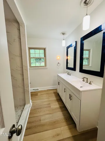 a large white kitchen with kitchen island a sink stainless steel appliances and cabinets