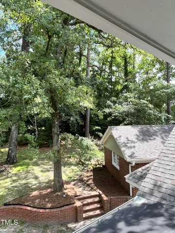 a view of a room with a ceiling fan and hardwood floor