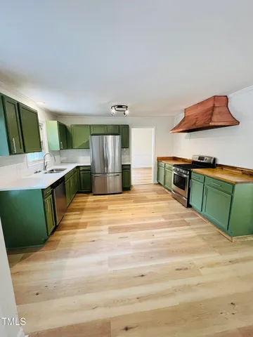 a kitchen with stainless steel appliances granite countertop a tiny refrigerator and a sink