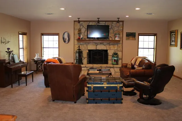 a living room with furniture a flat screen tv and a fireplace