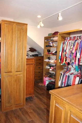 a view of walk in closet with clothes and shoes