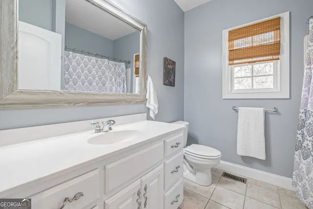 a bathroom with a sink a toilet and a window