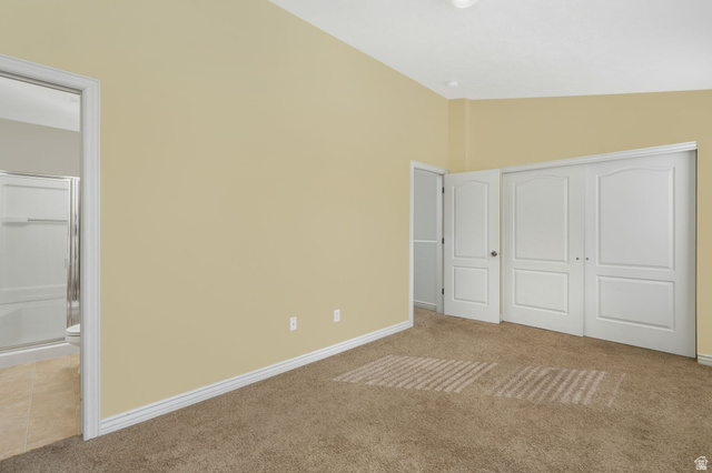 7936 Wycliffe Way Eagle Mountain, UT 84005 - Photo 14 of 37 Primary bedroom with light carpet, lofted ceiling, a closet, and connected bathroom