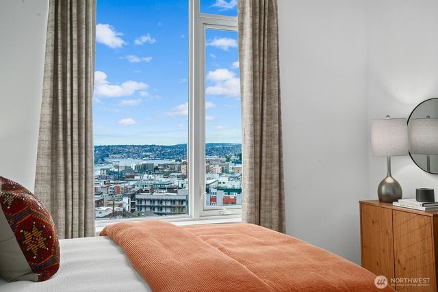 a bedroom with a large window and a bed