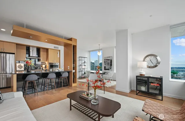 a living room with furniture a fireplace a rug and a large window