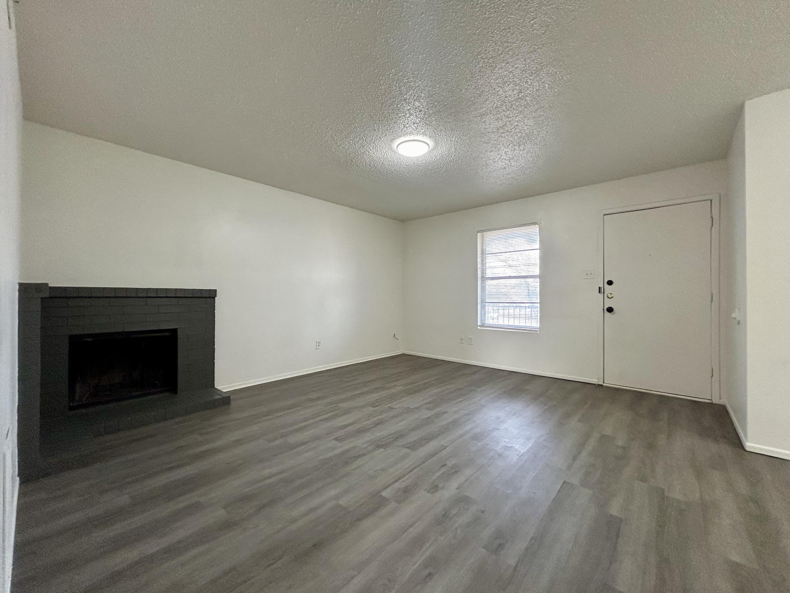 3204 Salisbury Avenue, Unit C Lubbock, TX 79410 - Photo 2 of 7 an empty room with wooden floor cabinet and windows