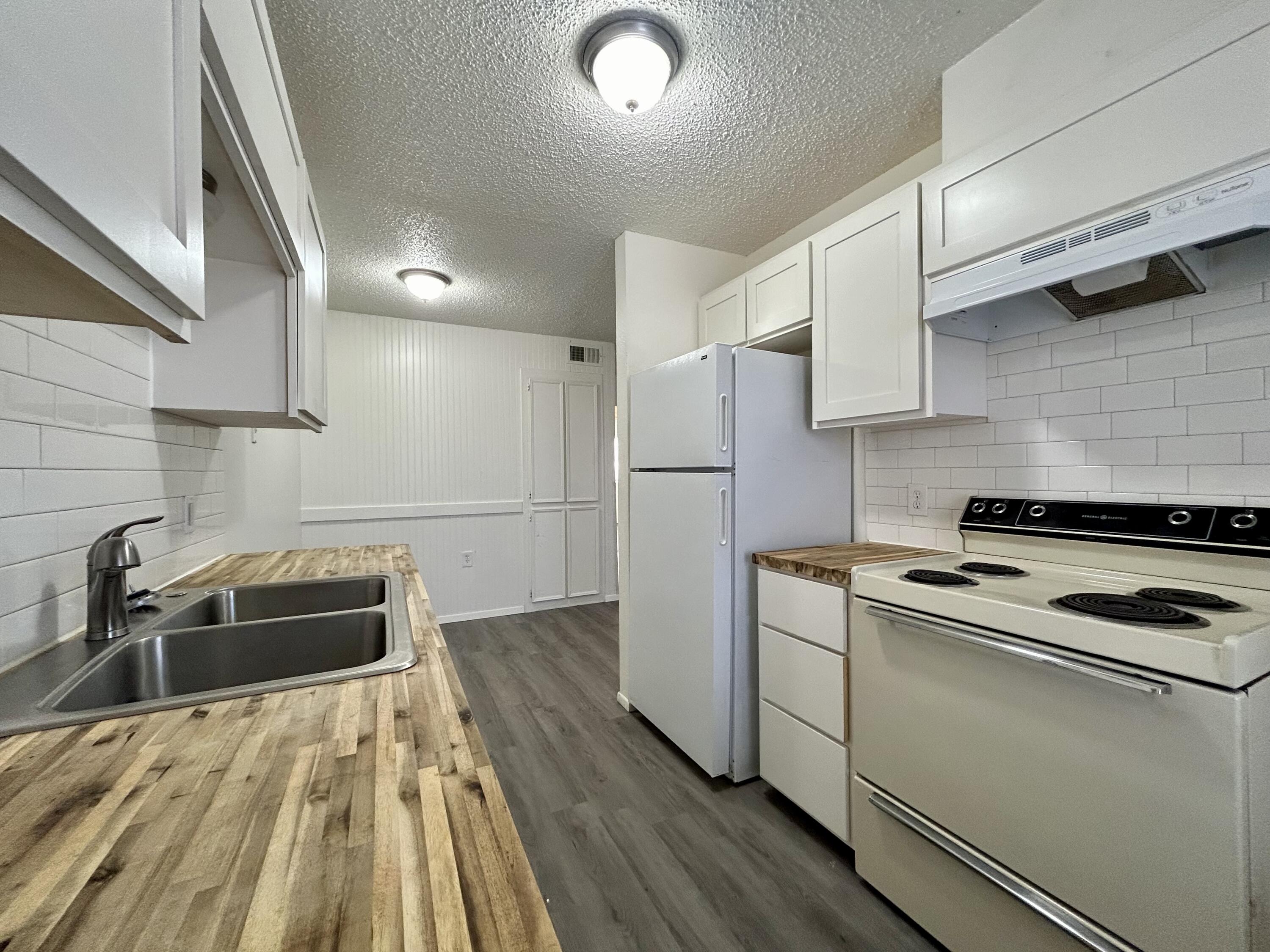 3204 Salisbury Avenue, Unit C Lubbock, TX 79410 - Photo 3 of 7 a kitchen with a sink a stove and refrigerator