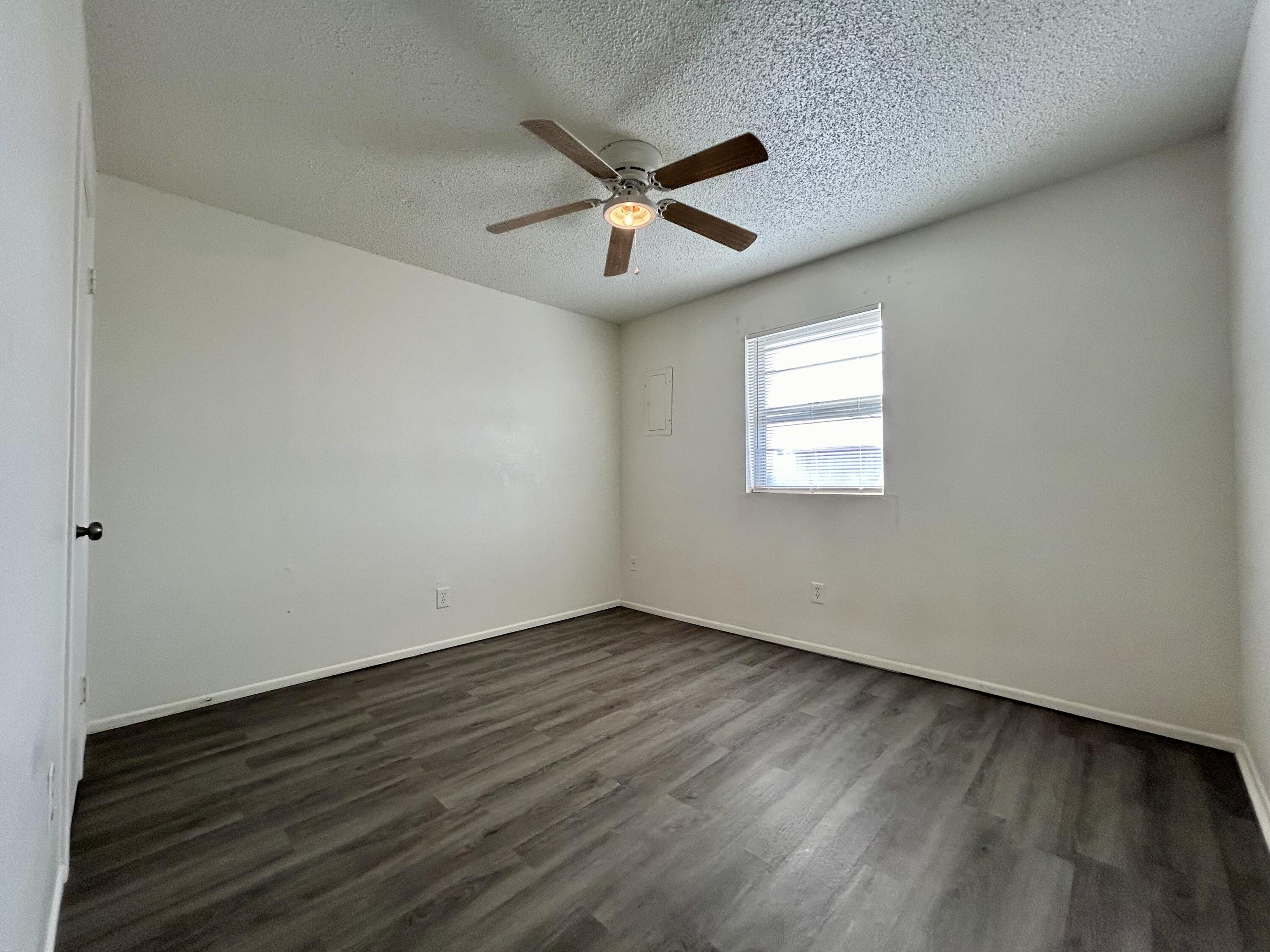 3204 Salisbury Avenue, Unit C Lubbock, TX 79410 - Photo 5 of 7 an empty room with wooden floor ceiling fan and windows