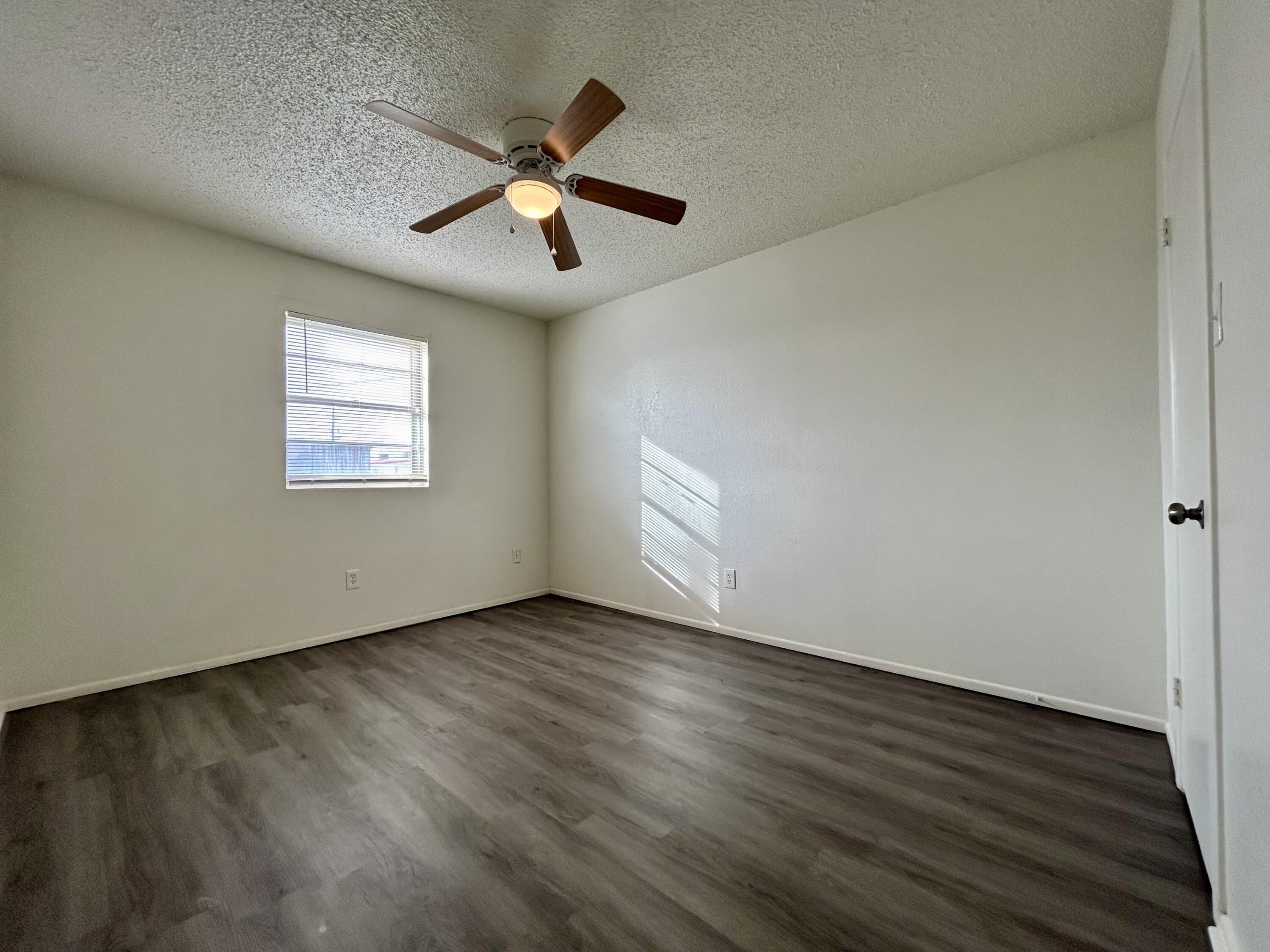 3204 Salisbury Avenue, Unit C Lubbock, TX 79410 - Photo 7 of 7 an empty room with wooden floor ceiling fan and windows