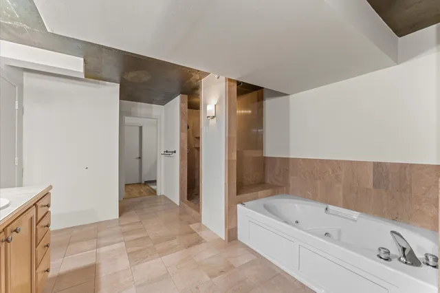 a bathroom with a double vanity sink a mirror and a bathtub