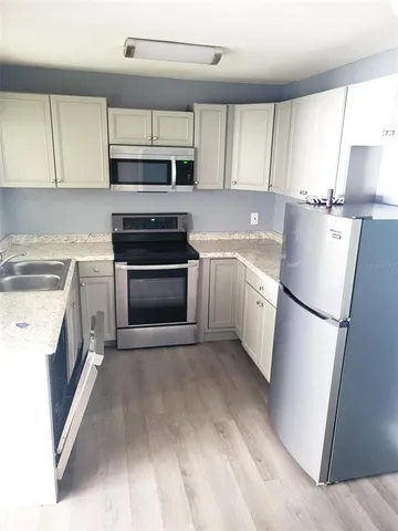 a kitchen with a sink a refrigerator and cabinets