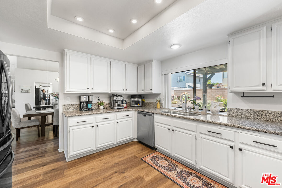 43258 33rd Street West Lancaster, CA 93536 - Photo 17 of 38 a kitchen with granite countertop white cabinets and white appliances