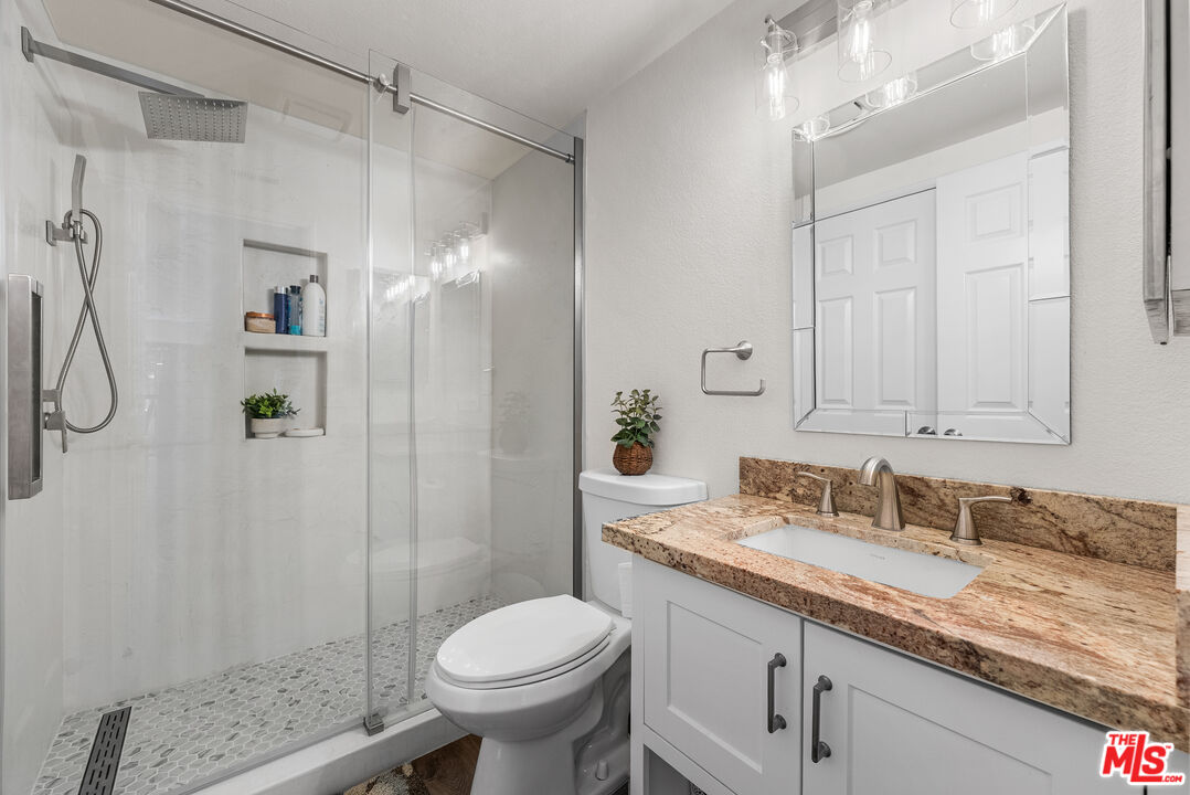 43258 33rd Street West Lancaster, CA 93536 - Photo 21 of 38 a bathroom with a granite countertop sink toilet and shower